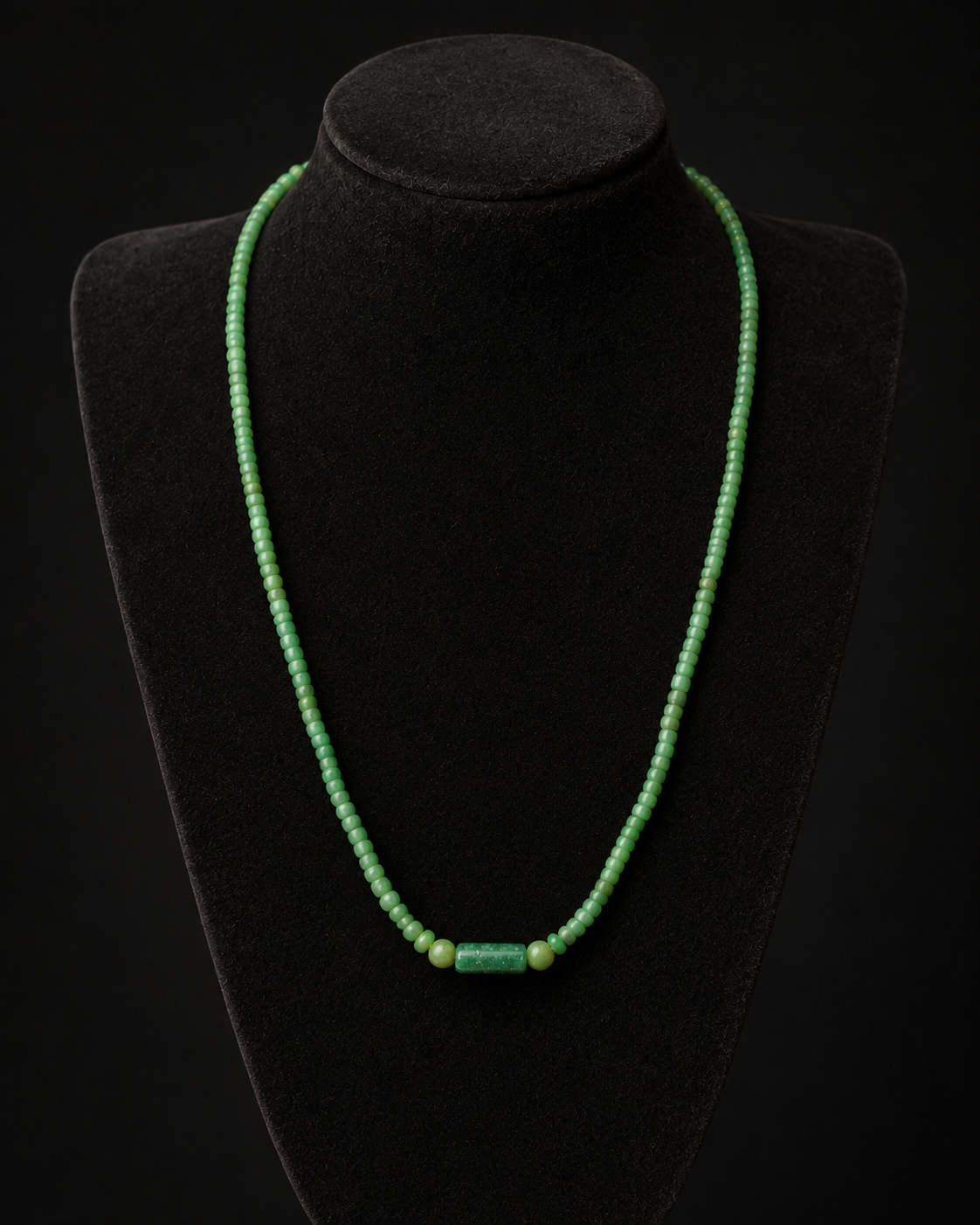 Roman green glass bead necklace on a charcoal museum bust