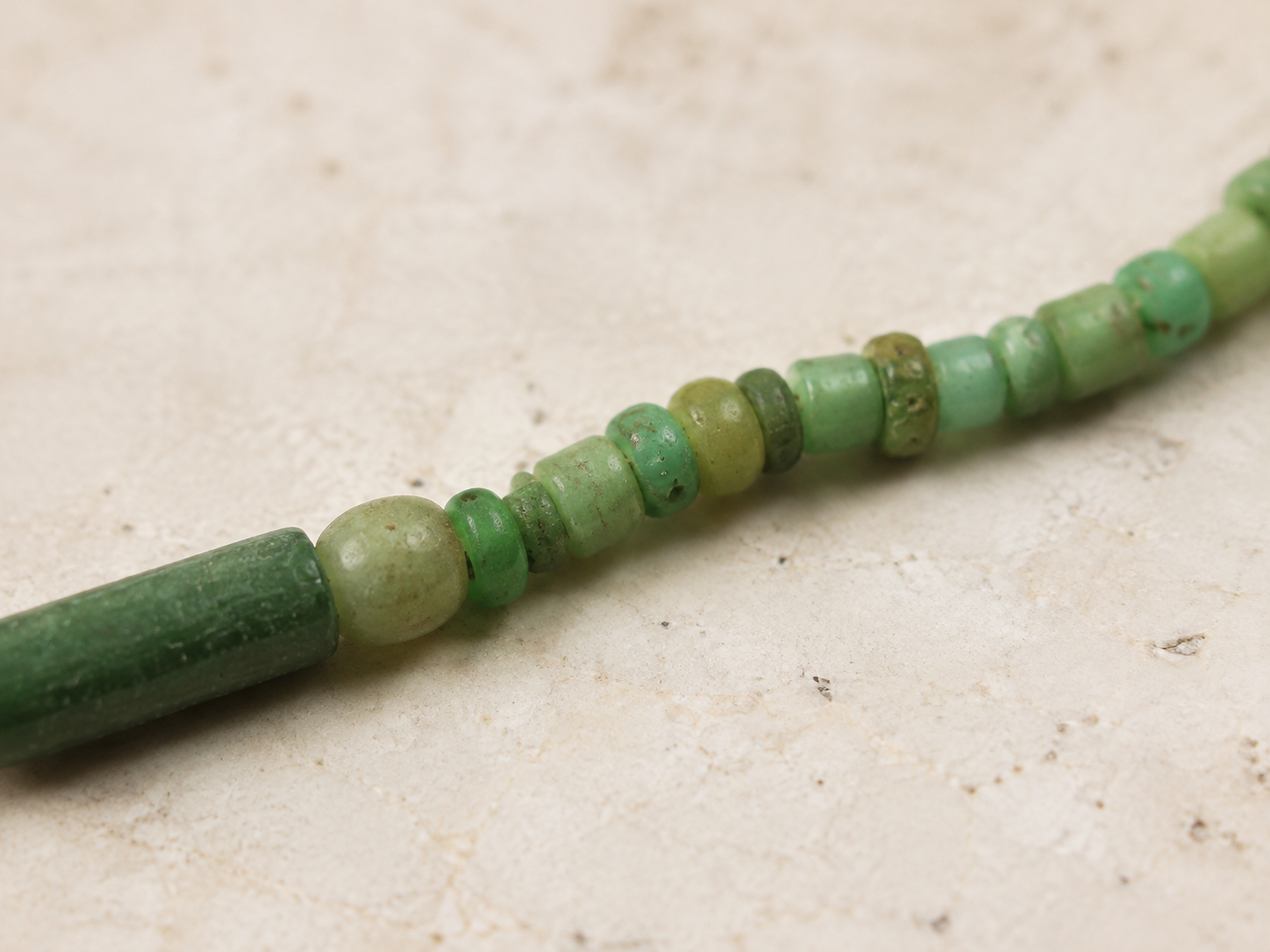 Macro detail of weathered Roman green glass beads